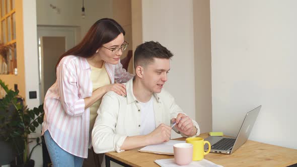Young Cheerful Couple Managing Finances, Reviewing Their Bank Accounts. alt