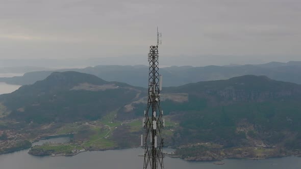 Modern telecommunication technology. Aerial reveal of 5G transmitter on mast tower, coastal landscap alt