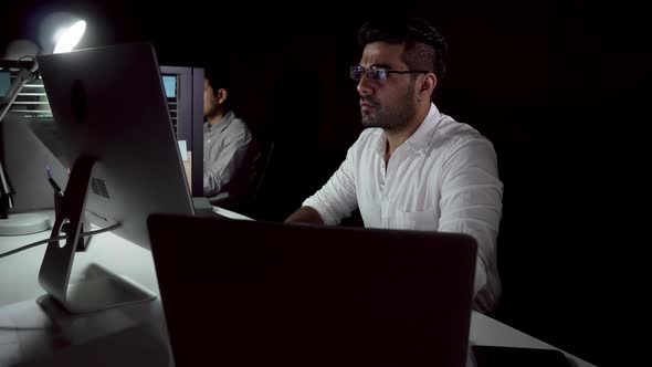 Asian business team seriously working on internet at night with client in different time zone