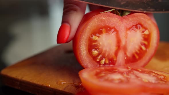 Woman with Red Manicure Cuts Tomatoes at Home Close Up