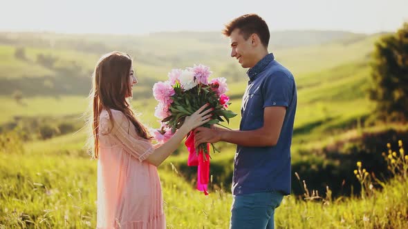 Man Is Giving a Bunch of Flowers To a Woman alt