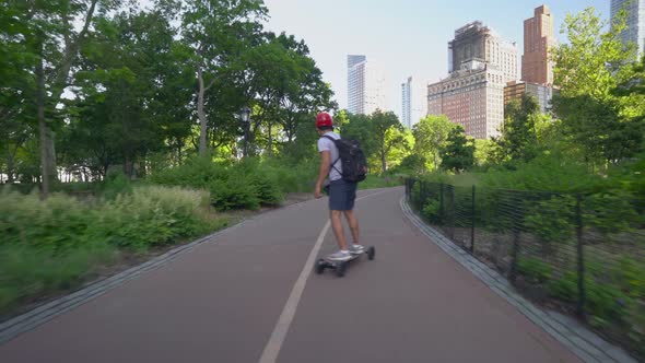 Man Riding An Electric Skateboard On A City Street