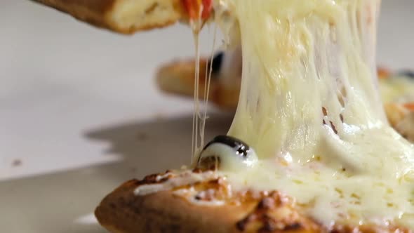 People man picks up sliced slice of pizza with melted cheese. Fast food close-up