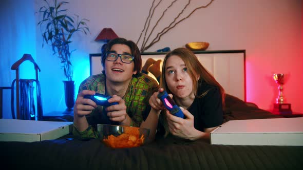 Girlfriend And Boyfriend Playing Video Games In Their Bedroom Stock