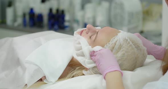 The Beautician Cleans The Skin With A Napkin After The Cosmetic Procedure. Beauty Clinic Concept alt