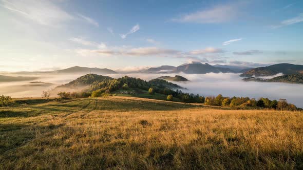 Foggy Morning Sunrise with Clouds Moving over Beautiful Country in Mountains alt