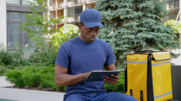 Camera Zoom in Afroamerican Man Courier Delivery Uses Tablet Looking Camera alt
