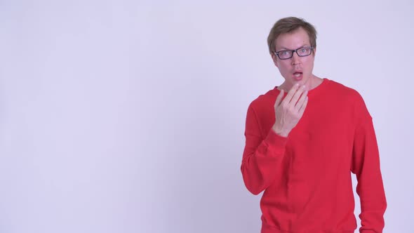 Young Handsome Man Touching Something and Looking Confused alt