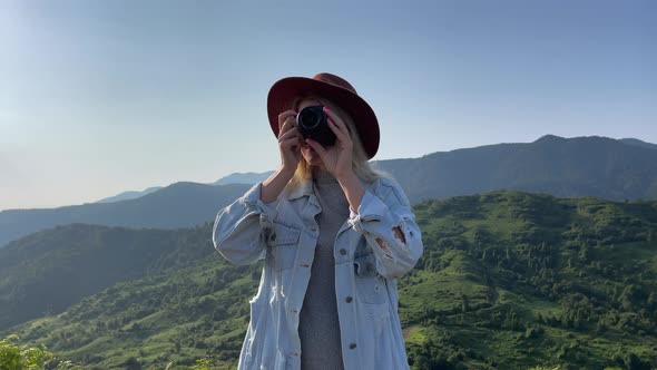 Photographer Takes a Pictures of a Mountains View on a Camera