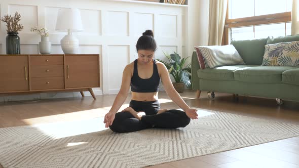 Young Woman stretching in living room at home. Young Indian Woman Meditating Sitting 