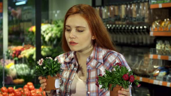 Woman Smells Different House Plants at the Supermarket alt
