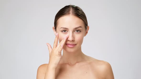 Beautiful Young Woman with Clean Fresh Skin Standing Over Light Grey Background alt