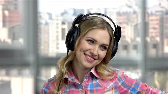 Portrait of Young Happy Woman Wearing Headphones and Talking alt
