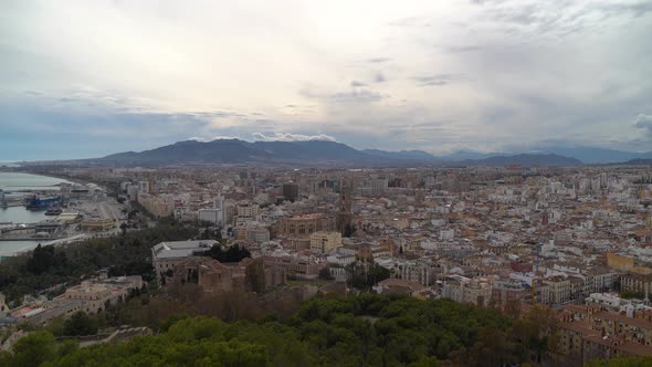 High above Panorama view over Malaga City with mountains on cloudy day alt