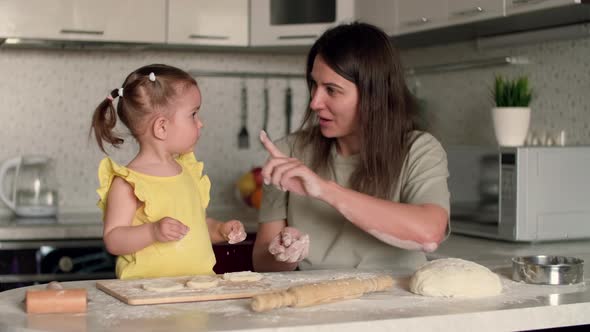 Cheerful Mom and Daughter While Cooking Baking at Home alt