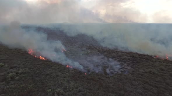 Aerial view of a small wildfire burning vegetation, Cambodia. alt