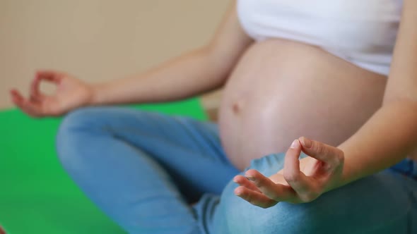 Pregnant woman meditating in lotus position