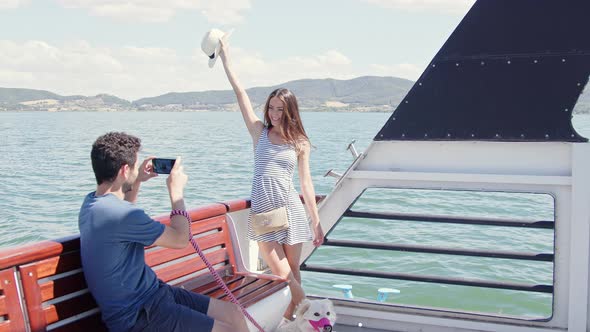 Happy couple taking pictures with smartphone on a boat trip alt
