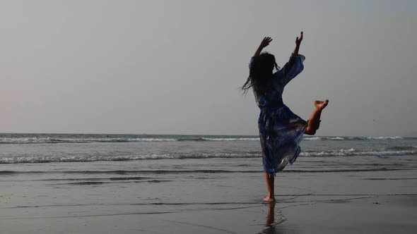 Silhouette of young girl dancing at sunset in slow motion alt