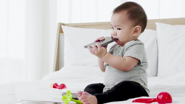 Cute baby girl playing with baby toys and smartphone. Smart funny child