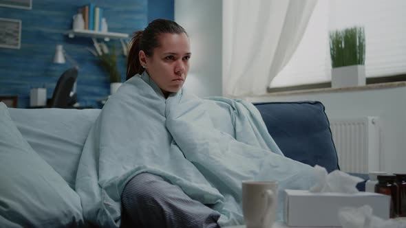 Sick Woman with Seasonal Flu Shivering in Blanket at Home alt