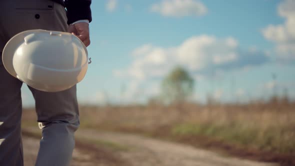 Electrical Engineer Holding Helmet Hard Hat On Power Lines. Worker With White Helmet After Hard Job. alt