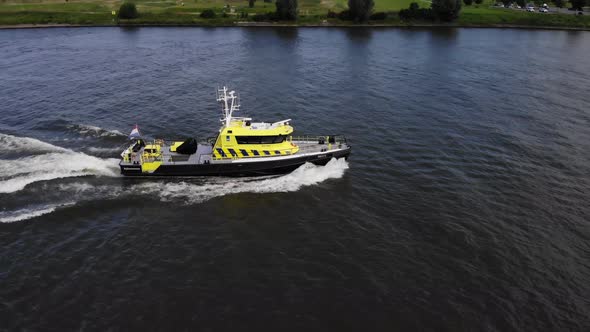 Dutch law enforcement vessel sailing on a river alt