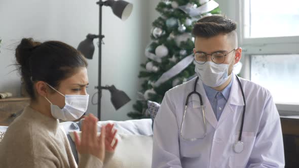 A Young Indian Woman wearing a Virus Mask Is Sitting on a Sofa with a Headache, A Doctor alt