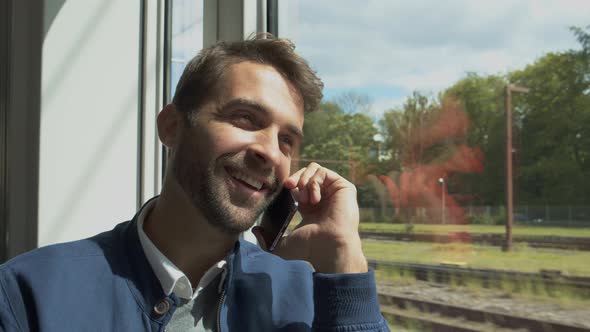 Man Traveling On Train And Answering Phone