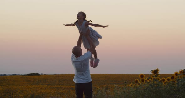 A Man Is Circling A Little Girl In His Arms