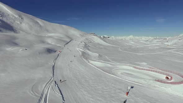 Aerial view of people skiing on a slope alt