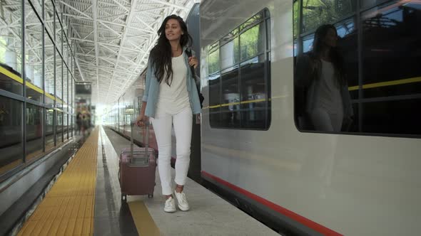 Woman Is Walking with Suitcase at Railway Station