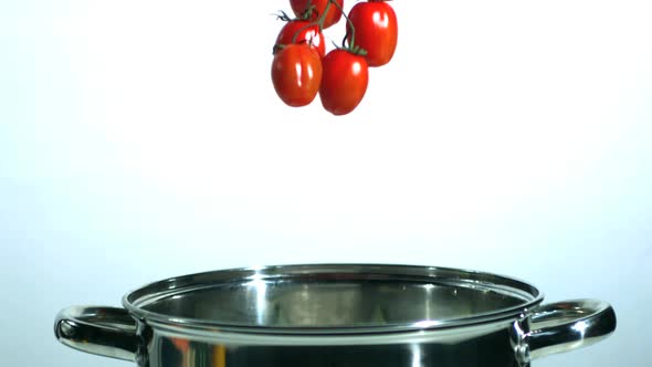 Vine tomatoes falling in saucepan