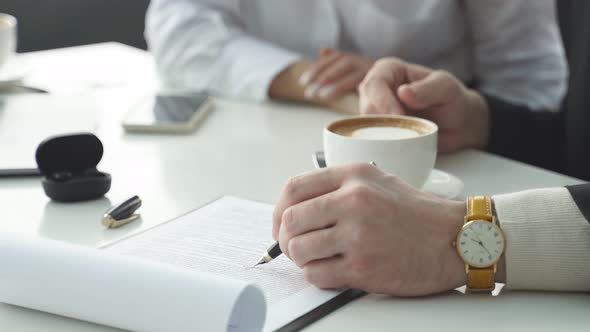 Closeup of a Table with a Laptop Two Cups of Coffee Female and Male Hands Without a Face alt