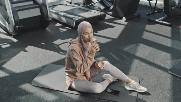 Muslim Woman Drinking Water in Gym alt