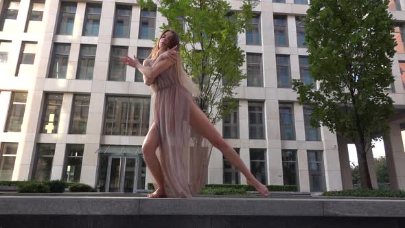 Beautiful Young Girl Dancing on the Street of a Modern Building of a Business Center. Slow Motion. alt
