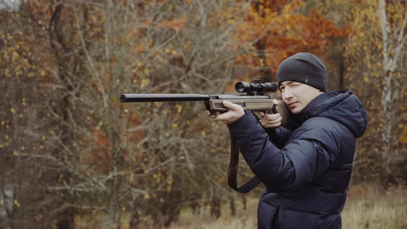 Hunter with gun on forest. Close up of the hunter man shooting with hunting  rifle on nature by vadimbad