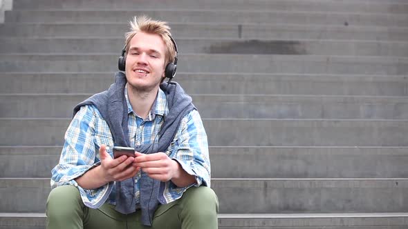 Young man relaxing and listening to music alt