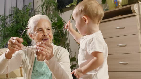 Grandmother and Baby Grandson Playing with Eyeglasses