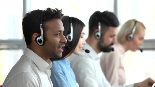 Black Employee in Call Center and Co-workers Behind. alt