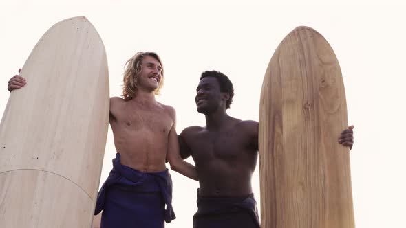 Young multiracial surfers having fun on the beach after surf session - People doing water sport alt