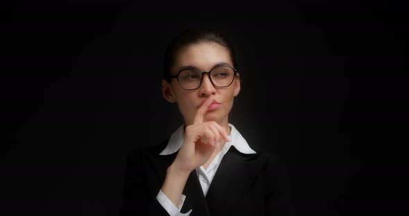 Businesswoman Thinks About Something Holds Her Index Finger Near Her Lips
