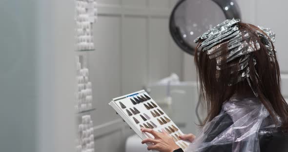 Young woman in hair salon getting her haircut by the hairdresser alt