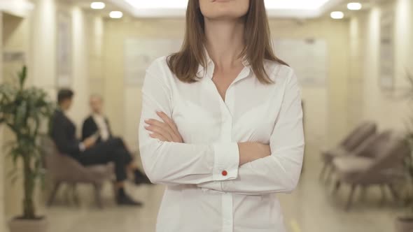 Unrecognizable Businesswoman Crossing Hands and Smiling in Business Center. Portrait of Confident alt