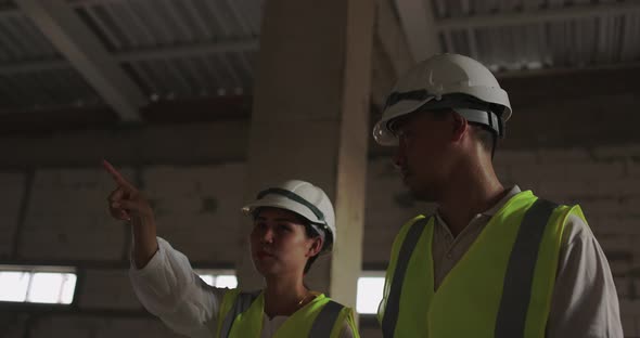 Industrial Engineers In Hard Hat Wearing Safety Jacket Working In The Building Site. alt