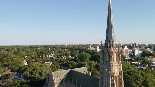 Aerial shot flying beside christian cathedral spire at golden hour alt