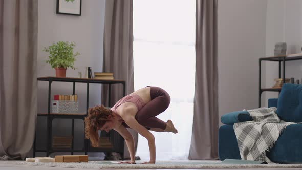 Sporty Strong Woman is Doing Handstand Practicing Yoga in Apartment Performing Asana for Balance and alt