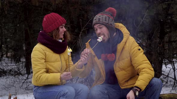 Young Man and Woman on a Picnic in the Winter Forest alt