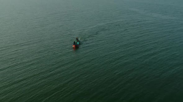 Aerial shot of Speeding Patrolling Boat At Keenjhar Lake In Thatta, Pakistan at sunset. alt