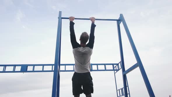 Young Man Doing Parkour Tricks on the Beach Near the Sea alt